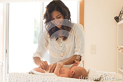 Mother changing baby`s diaper Stock Photo