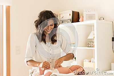 Mother changing baby`s diaper Stock Photo