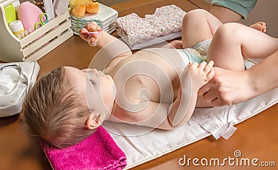 Mother changing diaper of adorable baby Stock Photo