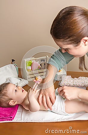 Mother changing diaper of adorable baby Stock Photo