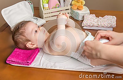 Mother changing diaper of adorable baby Stock Photo