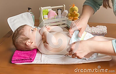 Mother changing diaper of adorable baby Stock Photo