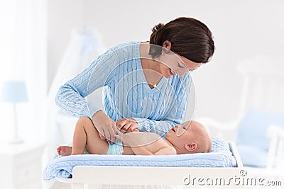 Mother changing diaper to baby boy Stock Photo