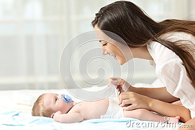 Mother changing diaper to her baby Stock Photo