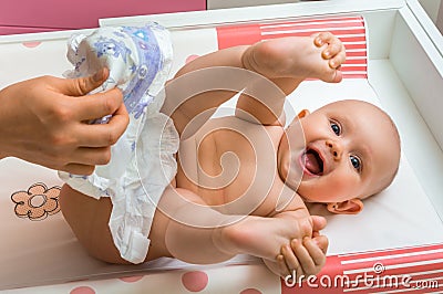 Mother changing diaper to her little baby girl Stock Photo