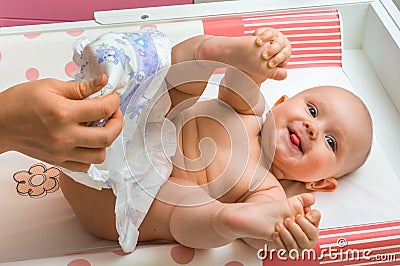Mother changing diaper to her little baby girl Stock Photo