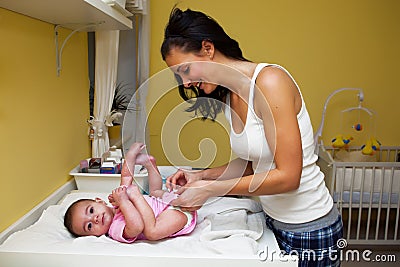 A mother changing her baby nappy . Stock Photo