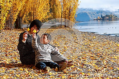 Mother and Child Boy Son plays in fallen leaves Stock Photo