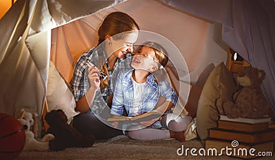 Mother and child daughter with a book and a flashlight before go Stock Photo