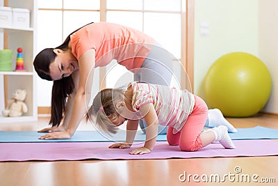 Mother and child daughter practicing yoga together at home. Sport and family concept Stock Photo