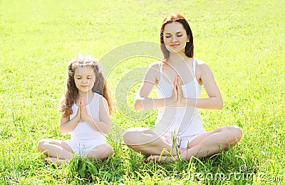 Mother and child doing yoga meditating in pose lotus Stock Photo