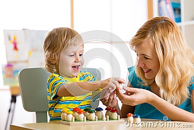 Mother and child learn color, size, count while playing with developmental toys. Early education concept. Stock Photo