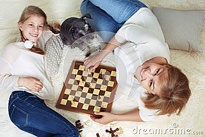 Mother and child are playing chess while spending time together Stock Photo