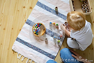 Mother and child playing educational game gnomes in barrels use Maria Montessori method development Stock Photo