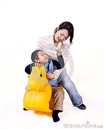 mother and child riding toy horse Stock Photo
