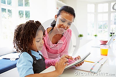 Mother And Child Using Digital Tablet For Homework Stock Photo