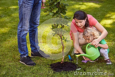 Mother and child watering tree Stock Photo