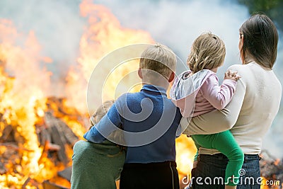 Mother with children at burning house background Stock Photo