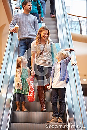 Mother And Children On Escalator In Shopping Mall Stock Photo