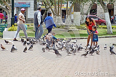 Mother and children feeding pigeons Editorial Stock Photo