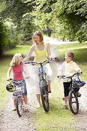 Mother and children riding bikes in countryside Stock Photo