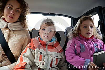 Mother with children sit on back seat of car Stock Photo