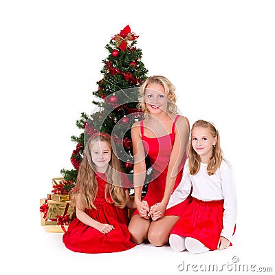 Mother with children sit near Christmas tree. Stock Photo