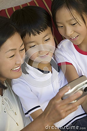 Mother and Children on sofa Looking at pictures on Digital Camera close up Stock Photo