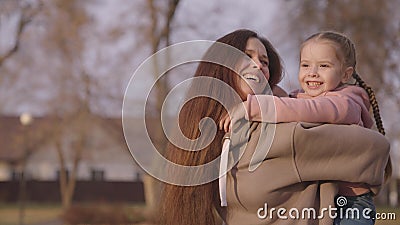 mother is circling child in her arms, cheerful kid with mom, happy family, children& x27;s dream of flying, baby smiles and Stock Photo