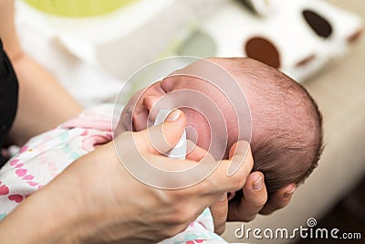 Mother cleaning eyes of a newborn baby Stock Photo