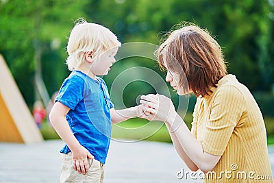 Mother comforting her son after he injured his hand Stock Photo