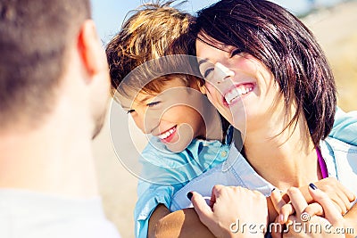 Mother cuddles her son while father watches them moved Stock Photo