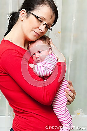 Mother cuddling baby girl Stock Photo