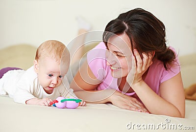 Mother with cute baby on bed Stock Photo