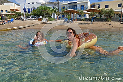 Mother and daughter bathe in the crystal clear sea of Kapsali in the south of the island of Kythira Editorial Stock Photo