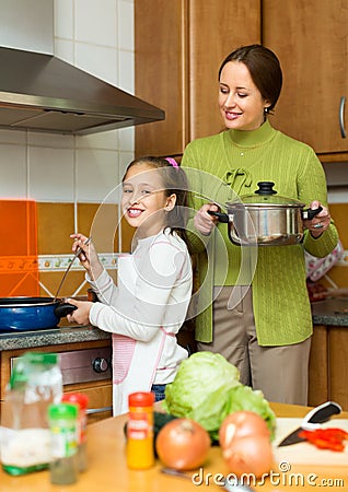 Mother with daughter cooking at kitchen Stock Photo