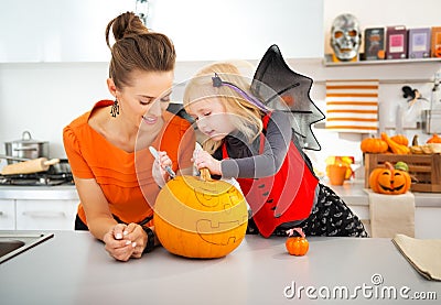 Mother with daughter creating Jack-O-Lantern on Halloween Stock Photo