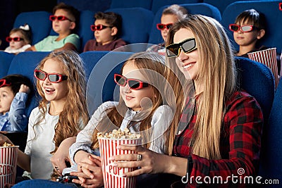 Mother and daughter in 3d glasses eating popcorn in cinema Stock Photo