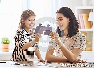 Mother and daughter do puzzles Stock Photo