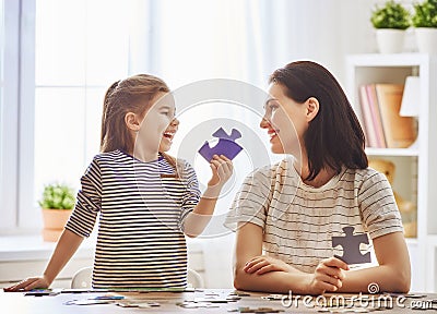 Mother and daughter do puzzles Stock Photo