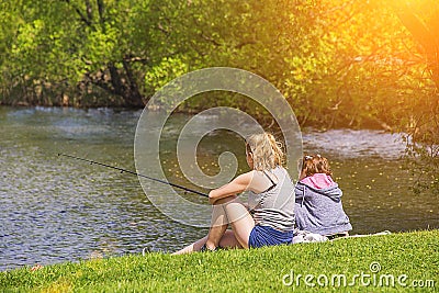Mother and daughter fishing in the lake, in the pond Stock Photo