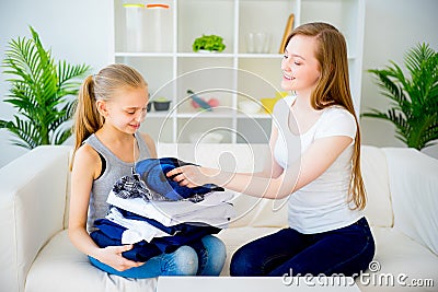 Mother and daughter folding laundry Stock Photo