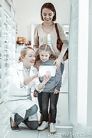 Mother and daughter looking at druggist s tablet interestedly Stock Photo