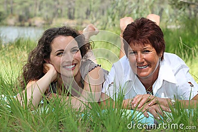 Mother and daughter lying in grass Stock Photo