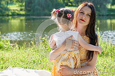 Mother and daughter in the Park by the lake. A girl embraces a woman Stock Photo