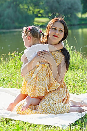 Mother and daughter in the Park by the lake. A girl embraces a woman Stock Photo