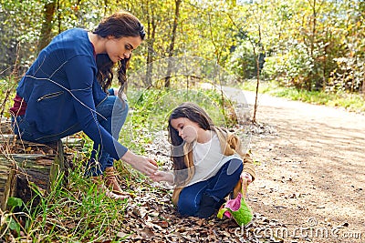 Mother daughter in a park picking clover plants Stock Photo