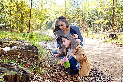 Mother daughter in a park picking clover plants Stock Photo