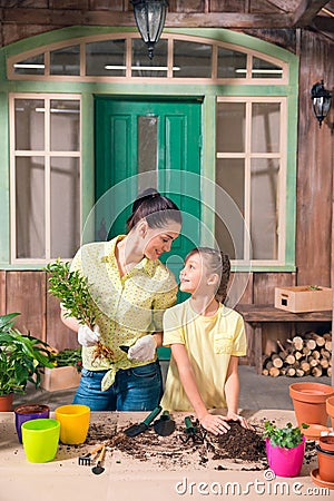 Mother and daughter with plants and flowerpots standing Stock Photo