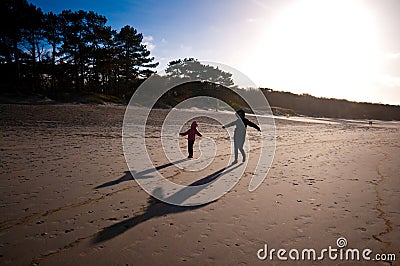 Mother and daughter play on beach Stock Photo